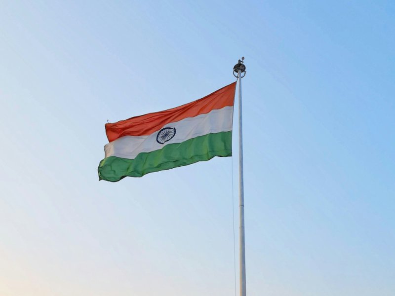 The Indian national flag flying on a flagpole.