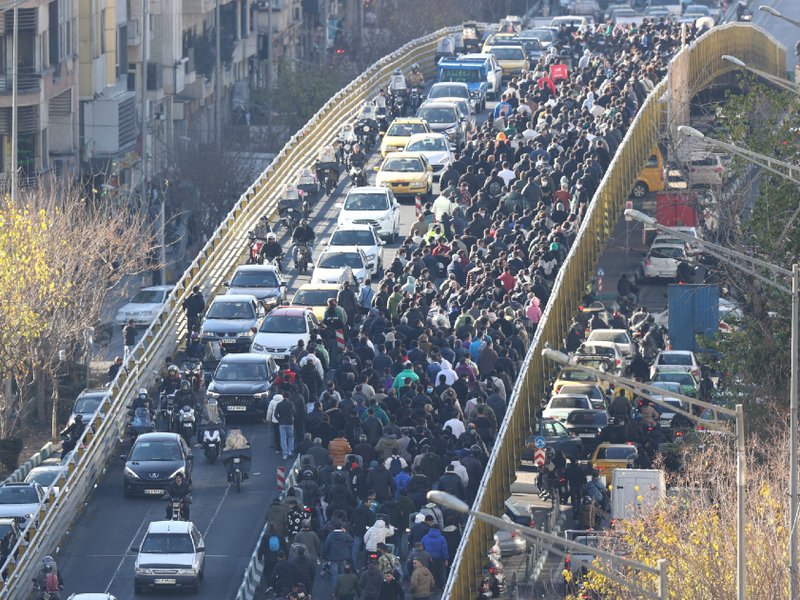Shopkeepers and traders walk over a bridge during a protest against the economic conditions and Iran's embattled currency in Tehran on December 29.