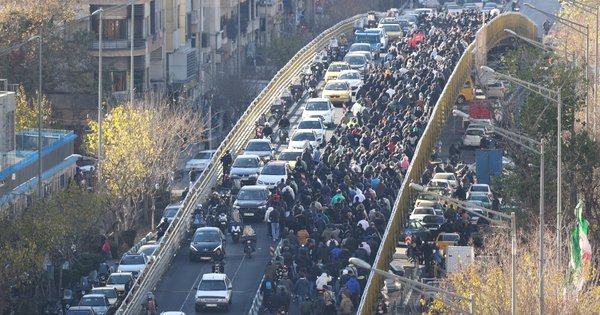 Shopkeepers and traders walk over a bridge during a protest against the economic conditions and Iran's embattled currency in Tehran on December 29.