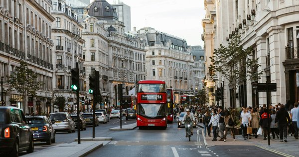 A view of a bus driving down a street in central London.