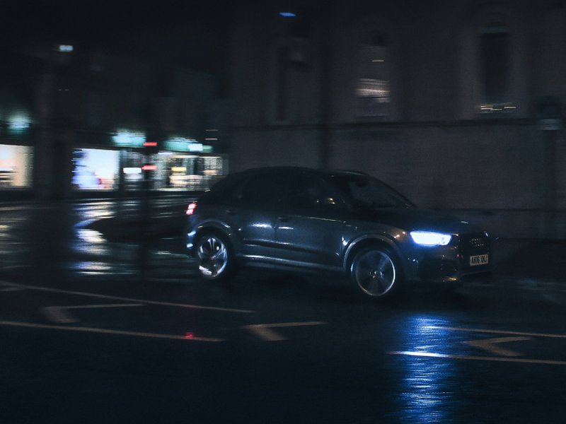 A car driving down a street at night