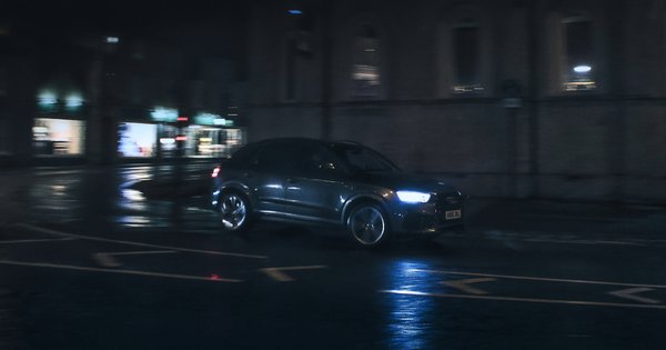 A car driving down a street at night