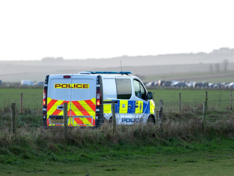 A police van parked in a field.