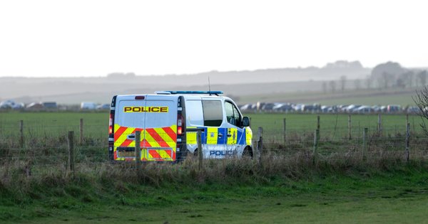 A police van parked in a field.