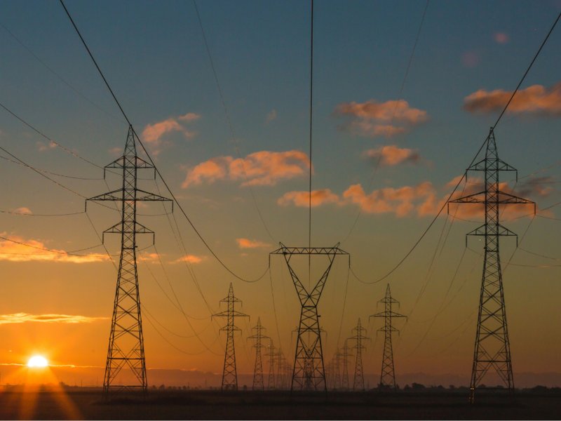 An image of electricity pylons at sunset.