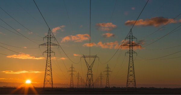 An image of electricity pylons at sunset.
