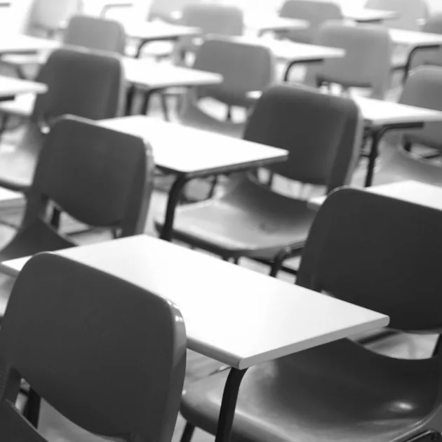 A picture of tables and chairs in a classroom.