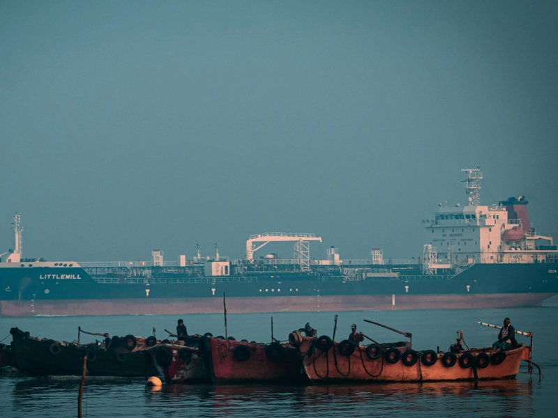 Wooden boats and cargo ship off the coast of Chittagong, Bangladesh