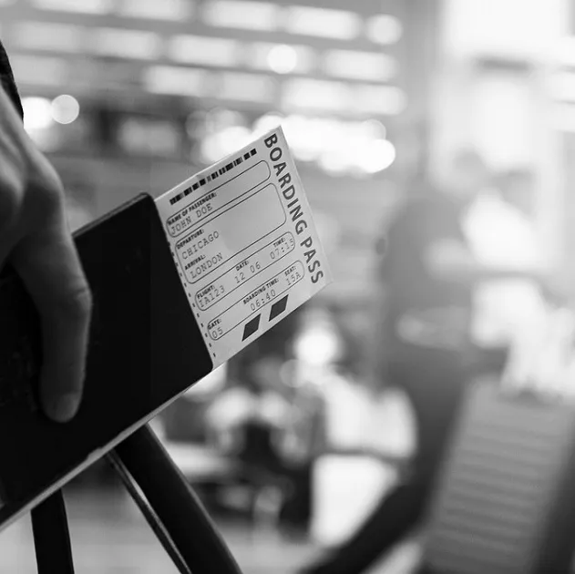 A person holding a boarding pass and passport.