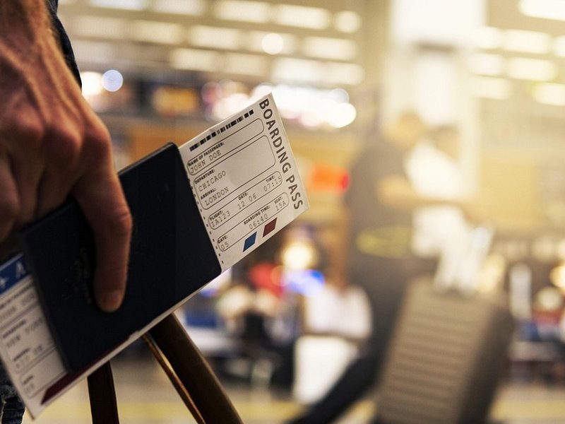 A person holding a boarding pass and passport.