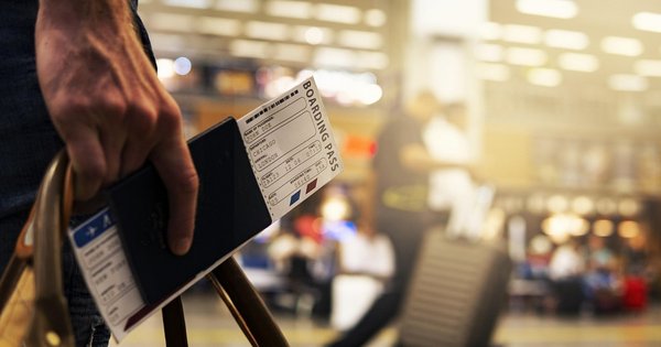 A person holding a boarding pass and passport.