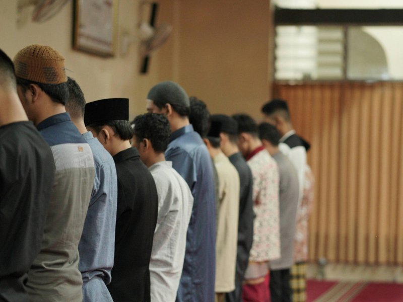 Group of men praying in a line