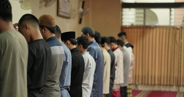 Group of men praying in a line