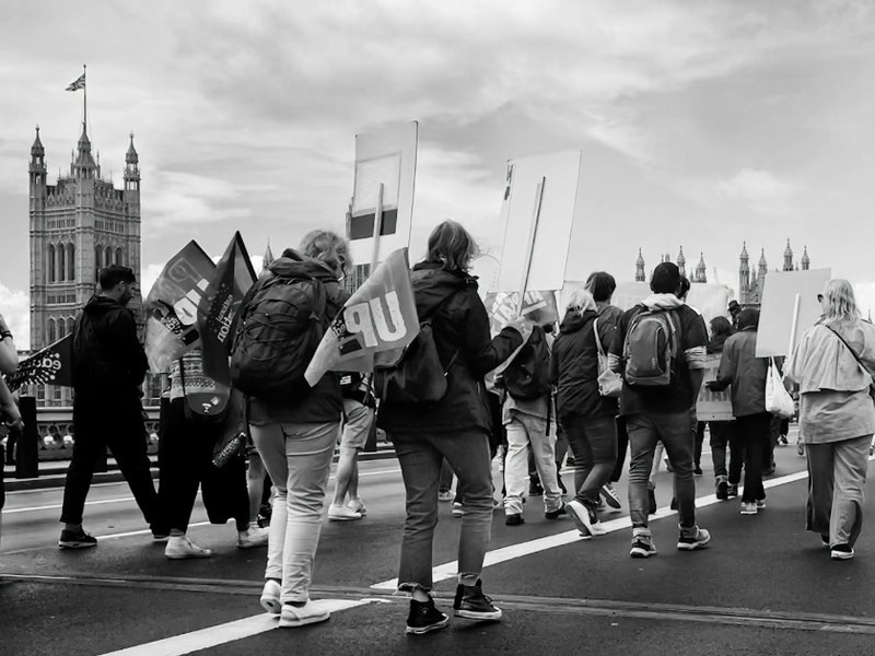 People walking down central London with signs