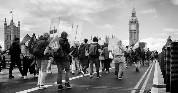 People walking down central London with signs