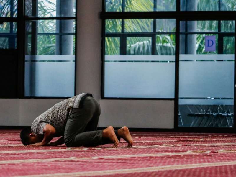 A man praying in a mosque.