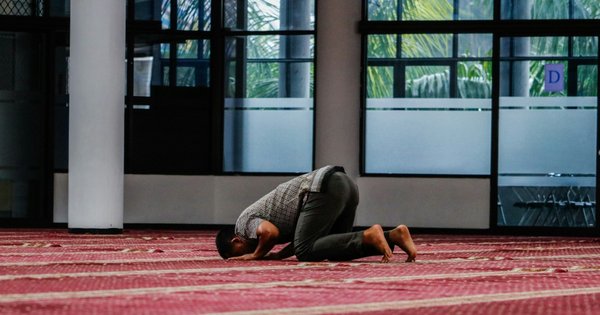 A man praying in a mosque.