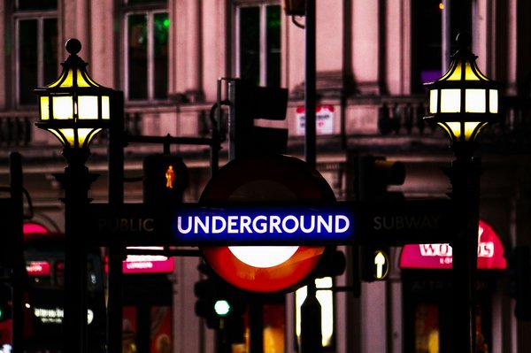 A photo of a London Underground sign at night.