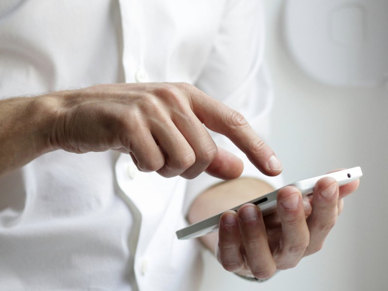 A photo of a man holding a smart phone.