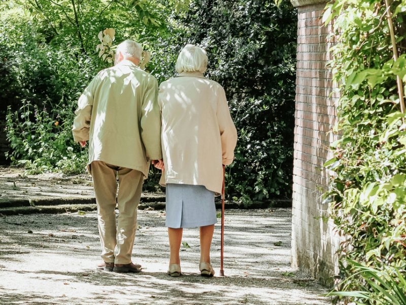 A picture of an elderly couple walking down a street.