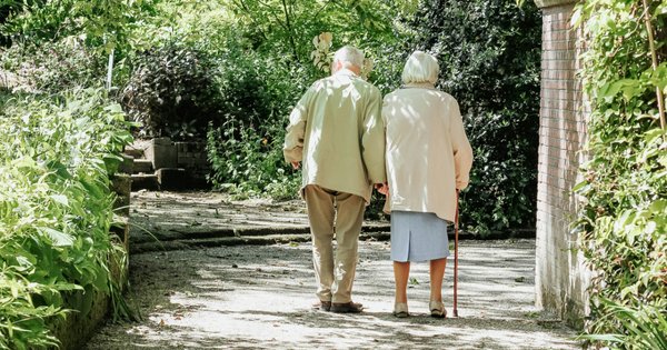 A picture of an elderly couple walking down a street.