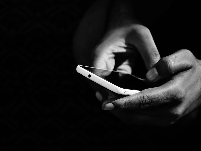 Black and white photo of someone holding a mobile phone