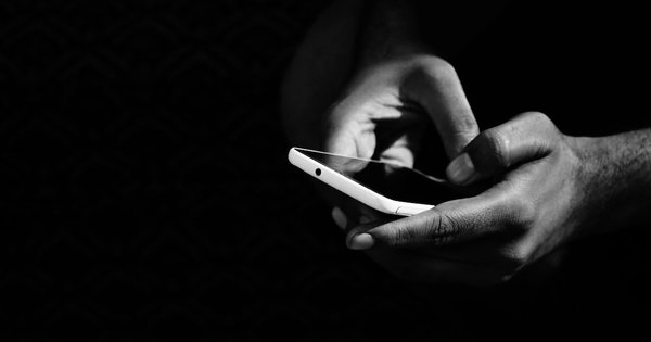 Black and white photo of someone holding a mobile phone
