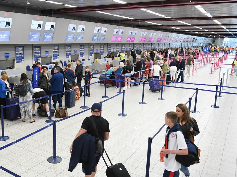 People queuing at an airport check in desk