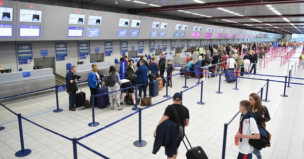 People queuing at an airport check in desk