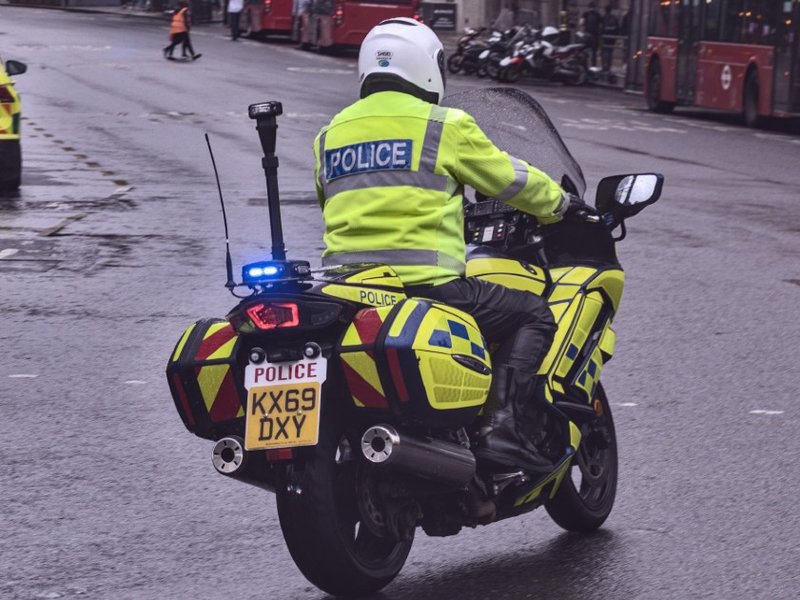 A police officer riding a motorcycle in London.