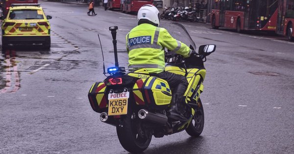 A police officer riding a motorcycle in London.