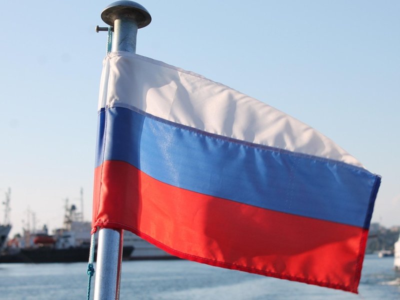 A Russian flag in front of a number of boats