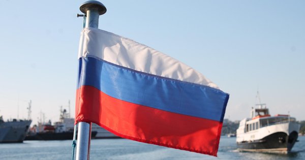 A Russian flag in front of a number of boats