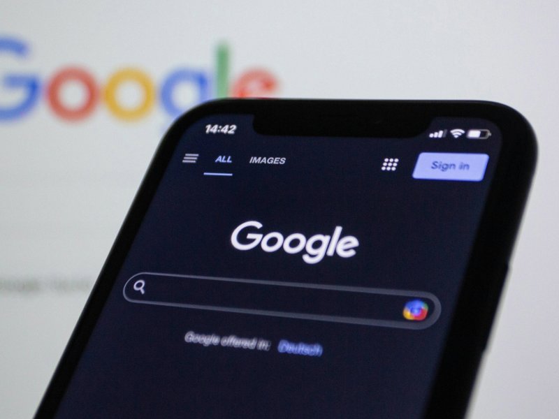 A photo of a mobile phone on the Google home page