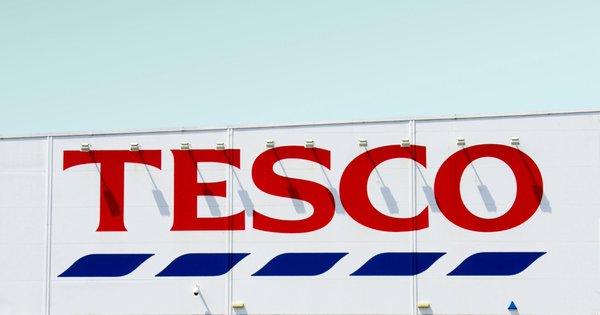 Tesco logo on a building in Slough, in front of blue sky.