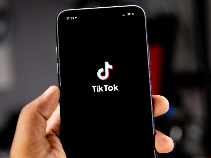 Person holding a mobile phone running TikTok.