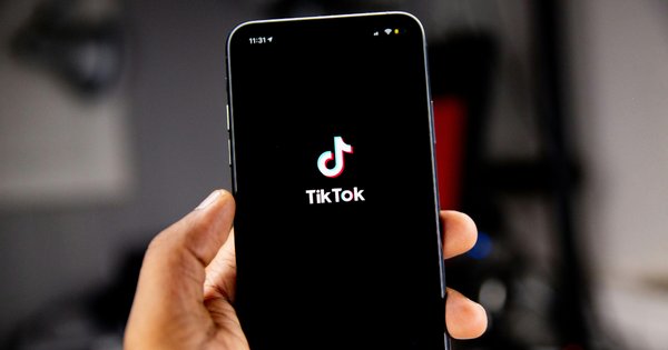 Person holding a mobile phone running TikTok.