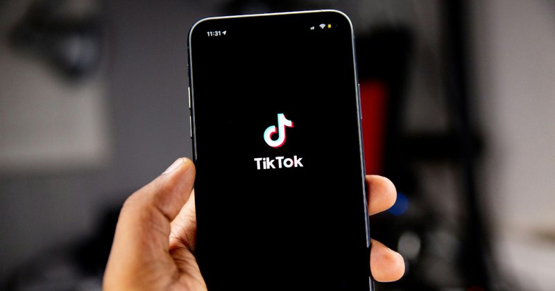 Person holding a mobile phone running TikTok.