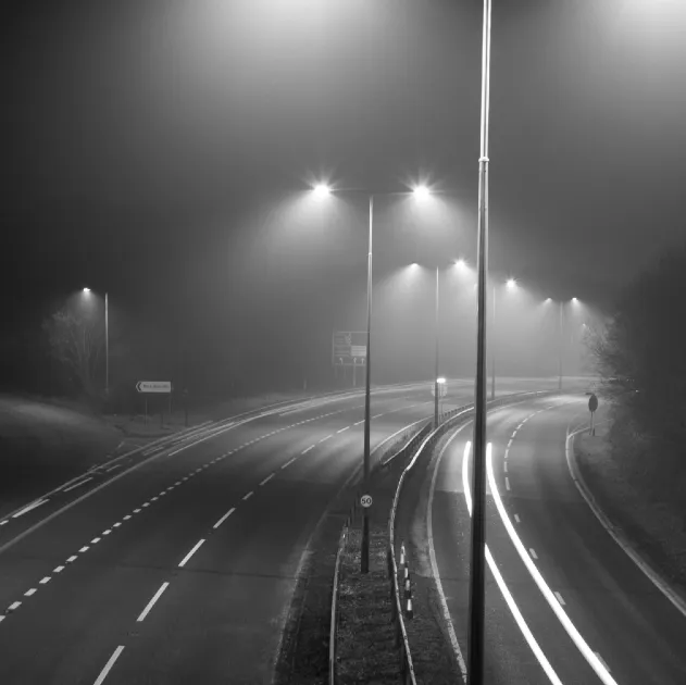 A road at night, lit by streetlights.
