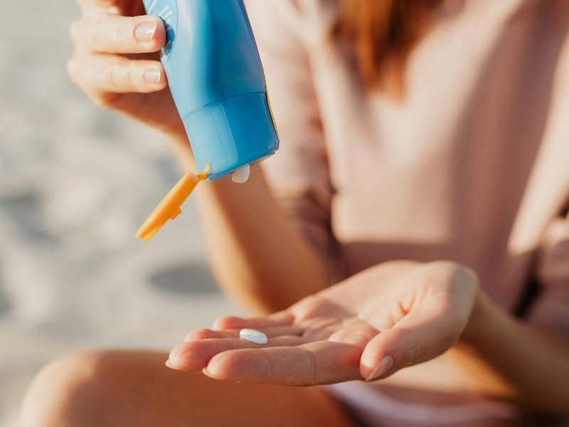 A woman putting suncream on her hand