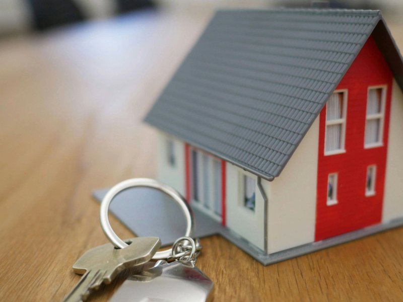 An image of a miniature house with a set of keys beside it.