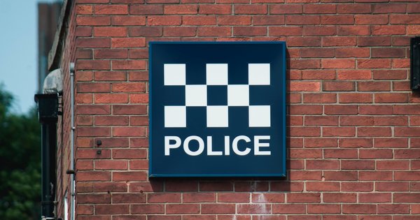 Police sign on brick wall