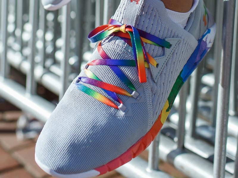 Feet wearing rainbow laces in a pair of trainers