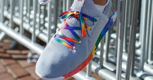 Feet wearing rainbow laces in a pair of trainers